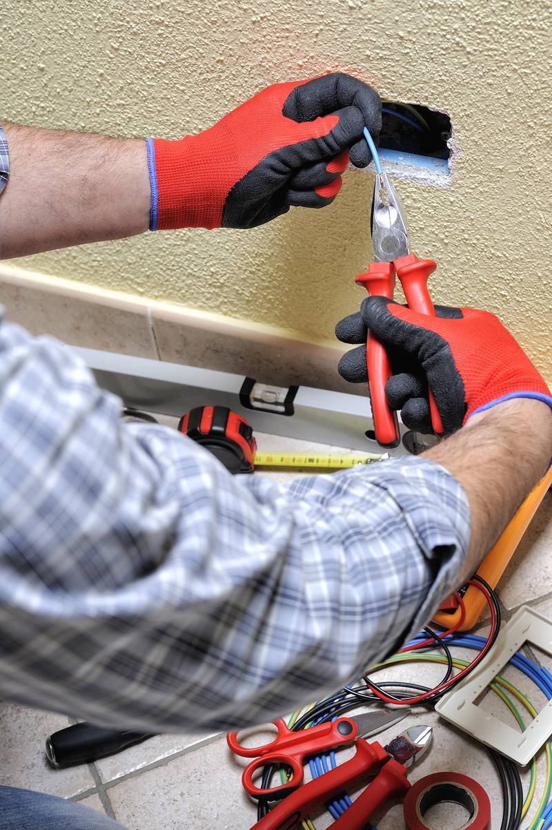 Electrician technician at work with safety equipment on a reside